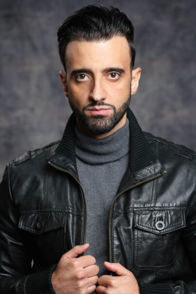 Fredi Abial actor primer plano con chaqueta de cuero y cuello alto gris