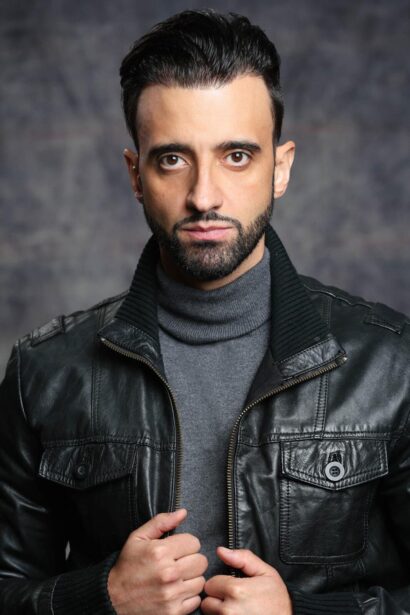 Fredi Abial actor primer plano con chaqueta de cuero y cuello alto gris